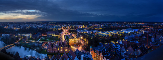 Luebeck, Germany – December 17, 2019:  Aerial night view panorama, illuminated city of Luebeck in...