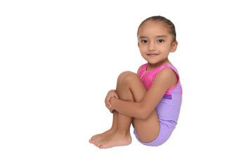small latin girl doing gymnastics with white background and purple sportswear