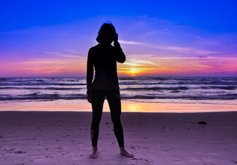 Silhouette of woman on the beach at sunset