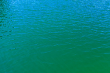 aerial view of the texture of the surface of turquoise water with sun reflections
