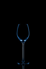 Wineglass toned in classic blue on the dark background.. Fine cristal glassware concept. Vertical