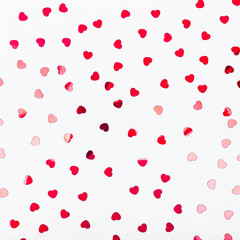 Grey background with red glitter heart confetti. Valentine day concept. Trendy minimalistic flat lay design background. Square