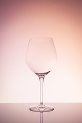 Red wine glass on creative background.. Fine cristal glassware concept. Vertical, warm tone