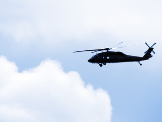 Black helicopter in clouds