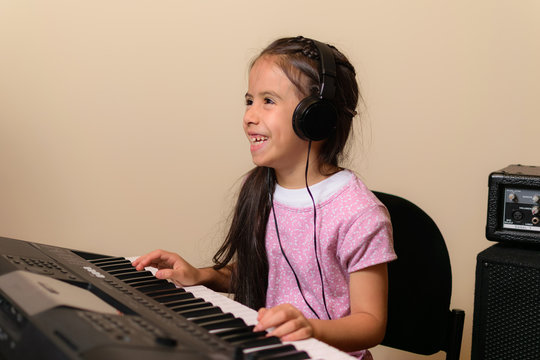 beautiful girl practices music on her electric piano