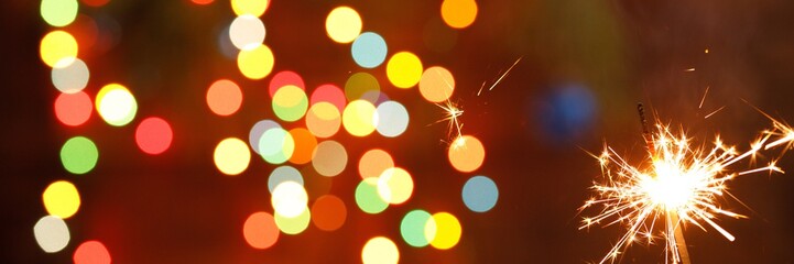 beautiful sparklers on the background of a garland. beautiful banner for the New Year.