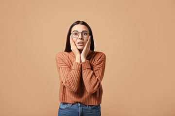 Portrait of worried young woman on color background