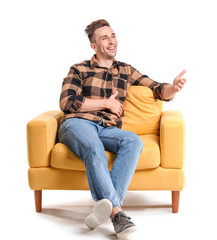 Handsome man sitting in armchair on white background