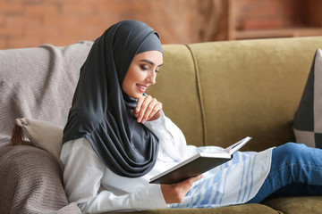 Beautiful Arab woman reading book at home