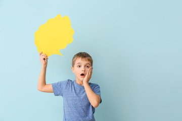 Surprised little boy with blank speech bubble on color background