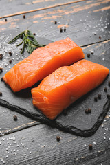 Raw salmon fillet on dark background