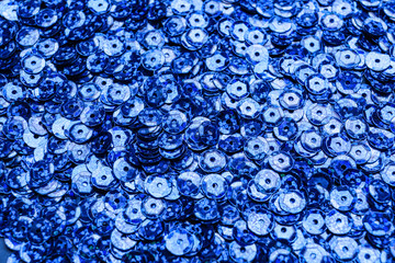 Many blue sequins on color background