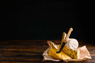 Assortment of fresh cheeses on wooden table