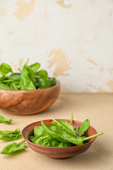 Bowl with fresh spinach on table