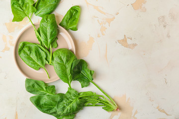 Plate with fresh green spinach on table