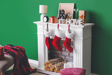 Christmas socks with gifts hanging on fireplace in interior of room