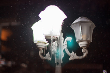 Fototapeta na wymiar snowfall over the street lamps