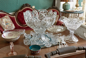 Vintage lead crystal punch bowl and cups on a wooden table at an antique store.  Maine, USA