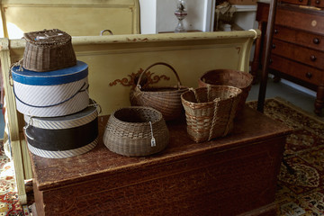 Vintage wooden bed and trunk decorated with wicker baskets at an antique shop.  Maine, USA