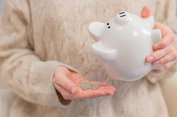 Woman is shaking piggy bank. Financial problem