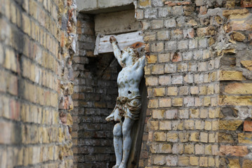 detail of a religious statue in old brick wall