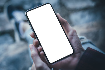 Mockup image blank white screen cell phone.man hand holding texting using mobile on desk at coffee shop.background empty space for advertise text.people contact marketing business,technology