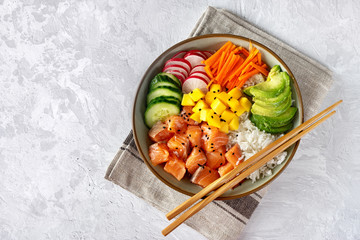 Top view of poke bowl with vegetables, rice and salmon