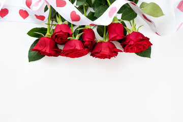 Red roses with ribbon on white background