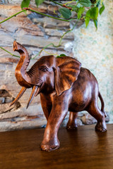Fototapeta premium cute brown wooden elephant on a background of stones