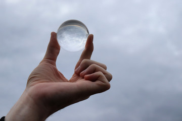 Hand holding glass sphere