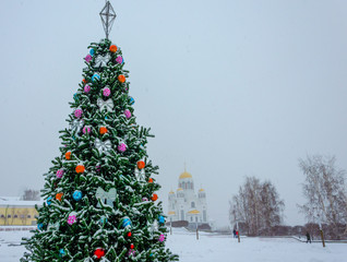 Toys on the Christmas tree in winter under the snow. Balls on a spruce branch for Christmas.