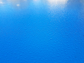 Blue surface covered in water droplets