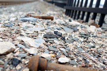 Rusty railroad tie abandoned bolt in gravel