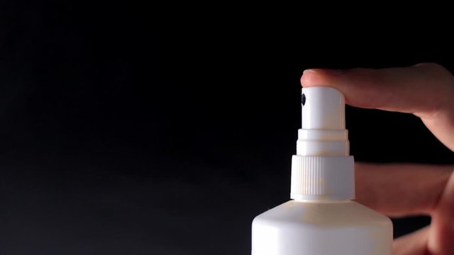 White spray bottle sprays aerosol / side view / 40% slow-motion