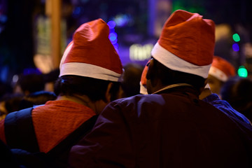Fototapeta na wymiar Boys are celebrating Christmas eve in night wearing Christmas cap on street at Kolkata.