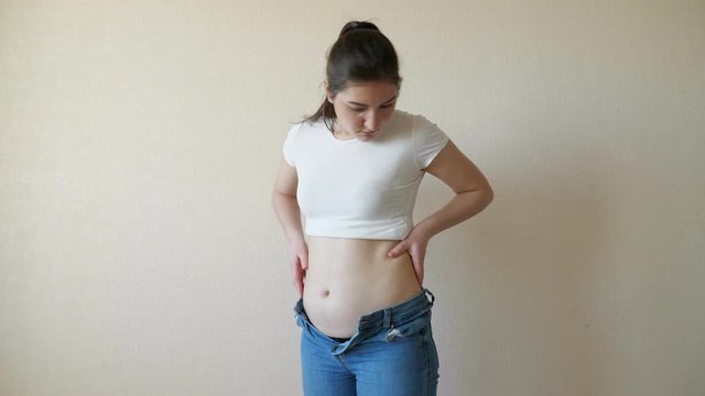 Chubby woman palpates the abdomen and flanks.