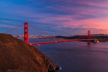 Panorama of the Golden Gate bridge with the Marin Headlands and San Francisco skyline at colorful sunset, California