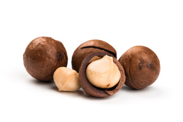 Raw not peeled whole macadamia nuts with shelled kernels isolated on white. Macro view. Healthy food. Protein source.