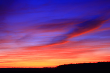 Very colorful clouds in dramatic sky. Romantic sunset at the countryside.
