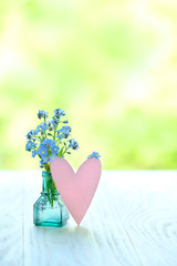 forget-me-not flowers and heart on green nature background. blue beautiful flowers close up. summer or spring season. romantic lovely image, Valentine's day, Mother's day greeting card. copy space