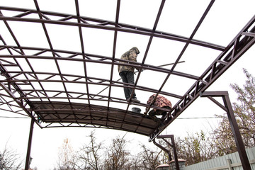 A worker mounts a metal canopy