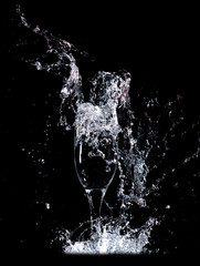 Water with splashes in a glass on a black background