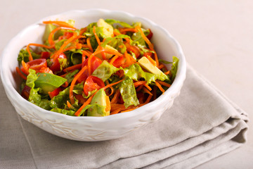 Healthy fresh salad with carrot, tomato and avocado
