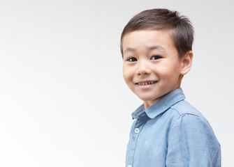 Portrait of a child in a blue shirt on a white background