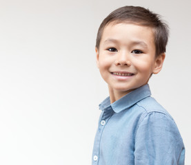 Portrait of a child in a blue shirt on a white background