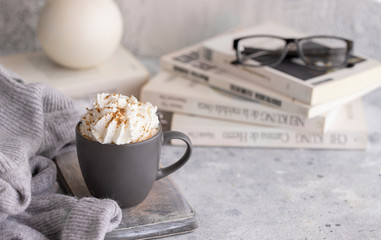 Mug of hot chocolate , candle, book and wool sweater.  Winter relax mood and hygge background.