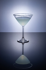Cocktail glass on a reflective surface