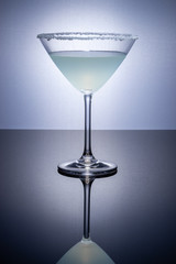 Cocktail glass on a reflective surface