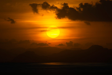 Sunset sky at the lake with dark clouds.