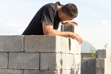 The builder builds a brick wall, close-up view of the construction workplace